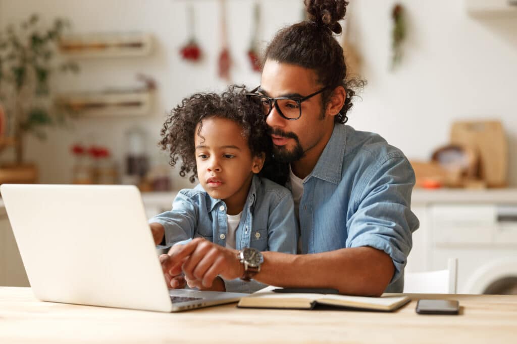 father and son pointing to a laptop