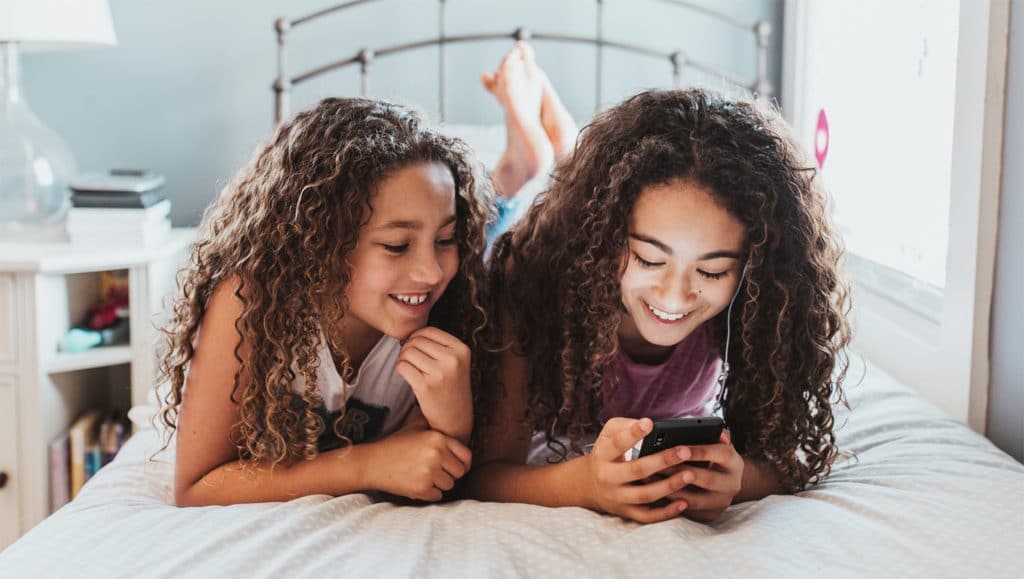 two happy girls looking at a phone