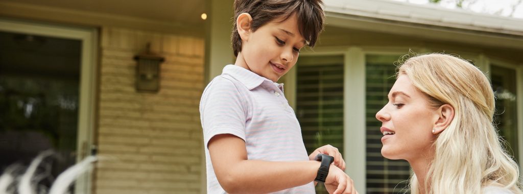 mother and son looking at his kids smart watch