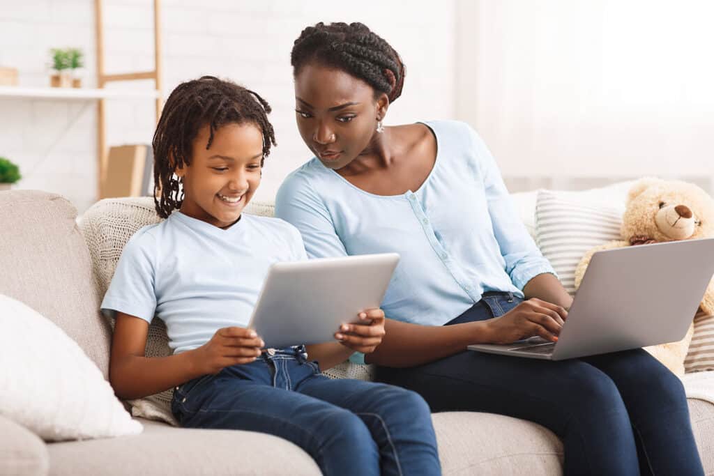 concerned mother and child looking at tech together