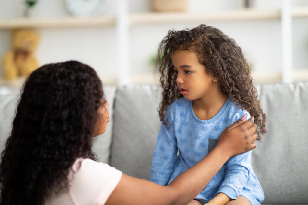 concerned mother lovingly talking to young daughter