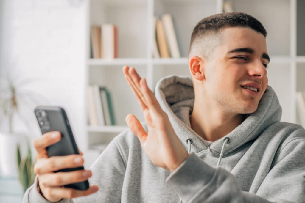 teen boy covers a phone screen